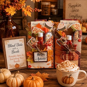 May include: Two wrapped book bundles decorated with autumn leaves, pumpkin stickers, and 'Hello Autumn' signs. A framed sign reads 'Blind Date with a Book, Pumpkin Spice & Everything Nice Bundle'. A mug with whipped cream sits beside small pumpkins.