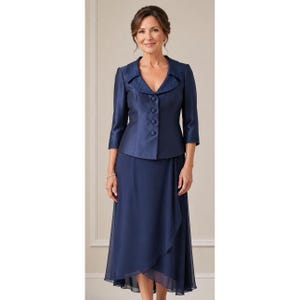 May include: A navy blue two-piece ensemble consisting of a structured jacket and a matching skirt. The jacket features three-quarter length sleeves, a V-neckline with textured lapels, and four fabric-covered buttons. The skirt is midi-length.