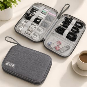 May include: A dark grey rectangular electronics organiser case with a wrist strap. The exterior features white icons of a USB drive, cable, and memory card. The interior is open, revealing elastic loops and mesh pockets holding various cables.
