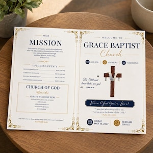May include: A bi-fold church bulletin for Grace Baptist Church featuring a white background with navy blue and gold text. The design includes a wooden cross with a white cloth, mission statement, upcoming events, and scripture verses from Psalms.