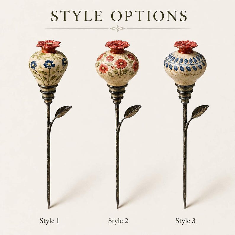 May include: Three decorative garden stakes labeled STYLE OPTIONS, Style 1, Style 2, and Style 3. Each features a bulbous ceramic top with a red floral cap and hand-painted patterns, mounted on a dark, textured metal stem with a single leaf.