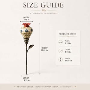 May include: A decorative garden stake featuring a cream-colored ceramic flower bud with blue petals and a red top, mounted on a dark metal stem with a single leaf. The text reads SIZE GUIDE, WIDTH 3.15 in, HEIGHT 11.81 in, LENGTH 3.15 in, and PRODUCT SPECS.