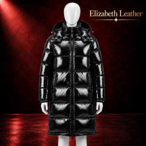 Peut inclure: Un manteau doudoune noir brillant de longueur moyenne avec une capuche, une fermeture éclair frontale intégrale et des panneaux matelassés horizontaux. Le texte Elizabeth Leather est imprimé en or en haut à droite sur fond rouge.