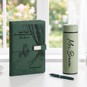 K&ouml;nnte beinhalten: Ein dunkelgr&uuml;nes Notizbuch mit einer Winnie Puuh-Illustration und dem Text Never Forget The Difference You Make Mrs. Brown Thank you Grace, eine hellgr&uuml;ne Isolierflasche mit dem Aufdruck Mrs. Brown und ein dunkelgr&uuml;ner Stift.