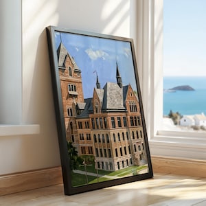 May include: A framed print featuring an oil painting of a multi-story brick building with a tall tower, steep gray roofs, and arched windows. The artwork displays a clear blue sky above the structure, which is set against a green lawn area.