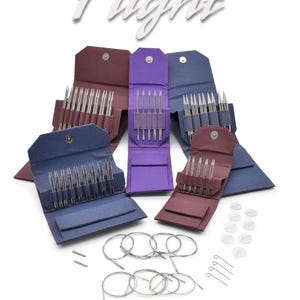 May include: Several sets of knitting needles in open cases, in shades of purple, blue, and burgundy. Silver circular needles, stitch markers, and the word "Flight" are also visible. The brand name "LYKKE" is displayed at the bottom of the image.