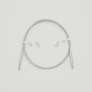 May include: A silver-colored circular knitting cable with metal tips and white paper tags. The cable is made of multiple strands of wire, and the metal tips have small holes. The cable is designed for knitting projects.