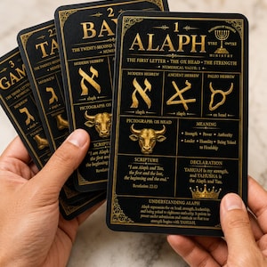 May include: A set of black rectangular cards with gold text and illustrations. The front card displays the number 1, the word ALAPH, and details about Hebrew letters, including an ox head symbol, scripture, and a crown icon at the bottom.