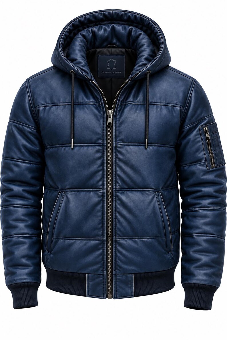 May include: A navy blue quilted leather jacket featuring a hood with drawstrings, a central metal zipper closure, two side pockets, and a zippered utility pocket on the left sleeve. The jacket has ribbed cuffs and a ribbed hem at the waist.