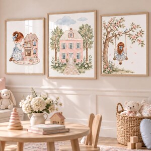 Könnte beinhalten: Drei gerahmte Wandbilder mit Aquarellillustrationen eines Kindes, das mit einem Puppenhaus spielt, einem rosa Haus mit Bäumen und einem Kind auf einer Baumschaukel. Die Kunstwerke sind in einem Raum mit einem Holztisch und Spielzeug ausgestellt.