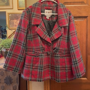 May include: Red and green plaid blazer with a black satin lining and two button closure. The label reads "AMJ".