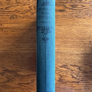 May include: A teal-colored book spine with the title "World War Events Vol. III" in black lettering. Decorative floral elements are above and below the title. The publisher's name, "Collier," is at the bottom.