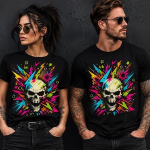 May include: Two black t-shirts featuring a vibrant graphic print of a skull surrounded by neon-colored lightning bolts, star shapes, and abstract splashes in shades of bright pink, electric blue, lime green, and yellow against a dark background.