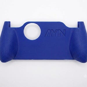 May include: A royal blue protective grip case for a handheld gaming console, featuring a textured surface on the side handles for improved grip and the embossed text AYN on the front panel, along with a circular cutout for a joystick.