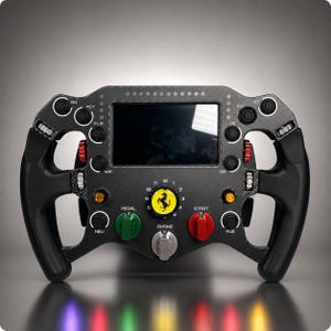 Può includere: Un volante da corsa in fibra di carbonio nera con display digitale centrale, l'emblema del cavallino rampante Ferrari giallo, diversi pulsanti etichettati e manopole rotanti in rosso, verde e argento. Il volante presenta impugnature nere ergonomiche.