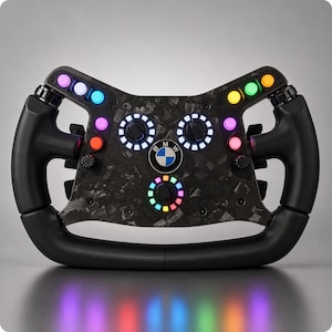 May include: A black carbon fiber racing steering wheel featuring a central BMW logo, three rotary dials with illuminated rings, and multiple colorful push buttons. The grips are finished in black, and the faceplate displays a marbled texture.