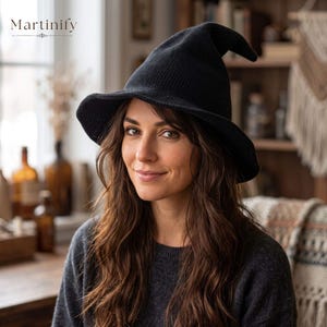 May include: A black knitted witch hat featuring a pointed crown and a wide, slightly curved brim. The hat is constructed with a textured, waffle-like knit pattern. The word Martinify is printed in the upper left corner of the image in a serif font.