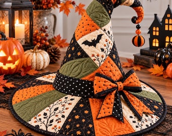 May include: A quilted witch hat featuring a patchwork design of orange, black, and olive green fabric with patterns of bats, stars, and berries. The hat has a curved tip with a dangling bead ornament and a large fabric bow on the brim.