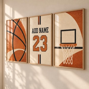 Könnte beinhalten: Ein Set aus drei vertikalen Wandbildern mit Basketball-Motiven. Das linke Bild zeigt ein Basketballmuster, das mittlere Bild enthält den Text ADD NAME über der Nummer 23 und das rechte Bild zeigt einen Basketballkorb mit einem Netz.