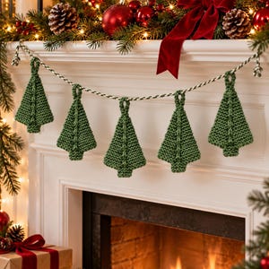 May include: A garland featuring five green knitted Christmas tree ornaments suspended from a twisted white and green cord. Each tree has a textured garter stitch pattern with a central vertical cable detail and a small loop at the top.
