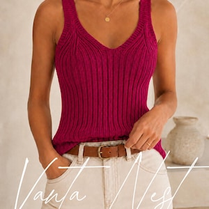 May include: A magenta sleeveless knit top featuring a deep V-neckline and vertical ribbed texture. The garment is paired with light-colored denim jeans secured by a brown leather belt with a gold-toned buckle. The text Vanya Vest is overlaid.