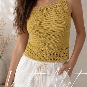 May include: A mustard yellow sleeveless crochet top featuring a square neckline and a decorative openwork pattern along the hem. The garment is paired with white drawstring trousers. The text Vanta Nest is overlaid in white script across the lower portion.