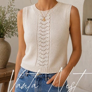 May include: A sleeveless cream-colored knit top featuring a round neckline and a vertical central panel with an intricate openwork leaf pattern. The garment has ribbed trim at the collar, armholes, and hem, paired with blue denim jeans.