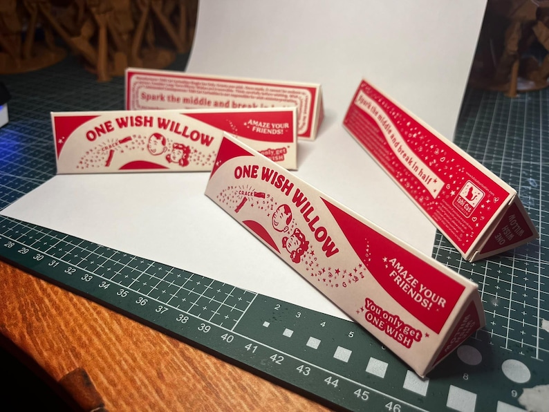 May include: Three triangular cardboard boxes with red and white graphics. The text reads ONE WISH WILLOW, AMAZE YOUR FRIENDS, and You only get ONE WISH. Each box features a cartoon illustration of two faces and stars, with instructions to spark the middle and break in half.