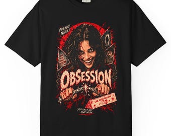 May include: A black short-sleeve t-shirt featuring a graphic print of a person with a wide smile. The design includes red splatters, the text "FREAKY NIKKI", "OBSESSION", "ONE WISH CHANGES EVERYTHING", "ONE WISH WILLOW", and "YOU ONLY GET ONE WISH".