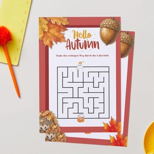 May include: A rectangular activity sheet featuring a maze with the text Hello Autumn and Finde den richtigen Weg durch das Labyrinth. The design includes illustrations of autumn leaves, an acorn, a small ghost, and a hedgehog in a pile of leaves.