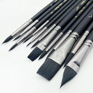 Peut inclure: Un ensemble de pinceaux d'artiste avec des manches en bois noir mat et des viroles en métal argenté. Les pinceaux présentent des poils synthétiques sombres de formes variées, notamment ronds, plats et en langue de chat. Le texte Lonely Finger est inscrit.