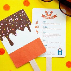 May include: Two paper fans on a yellow background. One is shaped like a popsicle with chocolate and sprinkles. The other lists event details, including ceremony, drinks, and disco. Confetti and sunglasses are also visible.