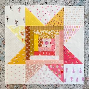May include: A quilt block with a log cabin pattern in shades of pink, yellow, and white. The block is made up of various fabrics with different patterns, including stars, butterflies, and strawberries.
