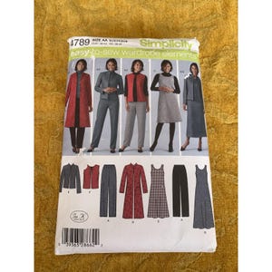 May include: A Simplicity 4789 sewing pattern envelope for easy-to-sew wardrobe elements in size AA. The front displays illustrations of various garments including a long red coat, a grey suit, a vest, a dress, and trousers with a barcode at the bottom.