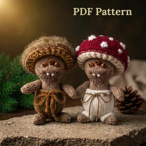 May include: Two knitted dolls with three eyes and two teeth. One doll wears a brown textured hat and green pants with a tie, while the other wears a red and white spotted mushroom hat and white pants. The text PDF Pattern is visible at the top.