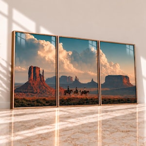 May include: A triptych wall art set featuring a desert landscape with red rock formations and three figures riding horses under a large, cloudy sky. The three framed prints are displayed side-by-side, showcasing a continuous panoramic view of the terrain.