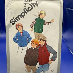 May include: A Simplicity sewing pattern envelope, number 5252, size 12. The front features illustrations of four individuals wearing various jackets, including a green vest, a blue jacket, a brown jacket, and a red and grey varsity-style jacket.
