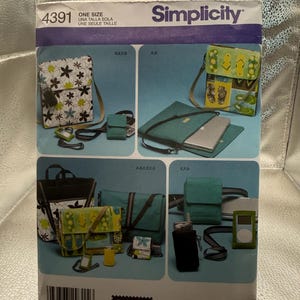May include: A Simplicity 4391 sewing pattern envelope featuring illustrations of various bags and pouches. The designs include floral patterns, flip-flop prints, and solid teal fabric. The envelope displays multiple bag styles, including shoulder bags, messenger bags, and small electronic cases, with a barcode and the text Elaine Heigl Designs at the bottom.