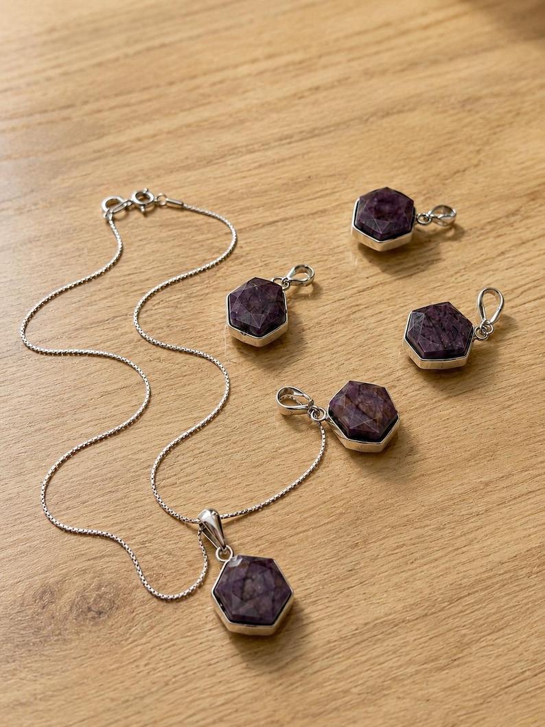May include: A silver chain necklace with a hexagonal purple gemstone pendant and four additional matching hexagonal purple gemstone pendants, each set in a silver frame with a small metal loop for attachment to a chain or cord.