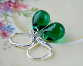 May include: A pair of silver dangle earrings with teardrop-shaped green glass beads.