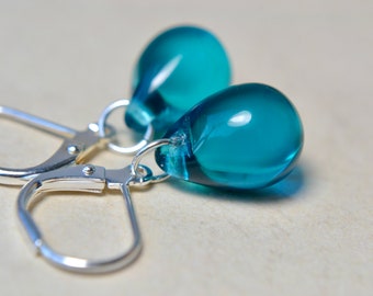 May include: Teal blue glass teardrop earrings with silver leverback closures.