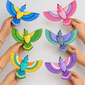 May include: Six colorful bird cutouts with spread wings, each featuring distinct color combinations including blue and yellow, pink and purple, green and yellow, blue and teal, turquoise and yellow, and purple and pink, all with black outlines.