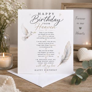 Puede incluir: Una tarjeta de felicitación blanca con el texto Happy Birthday From Heaven, que incluye un poema, una paloma blanca volando y una ilustración de una pluma. La tarjeta tiene pequeños corazones y la frase with all my love, Happy Birthday.