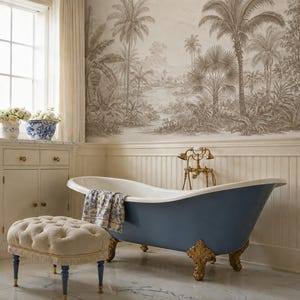 May include: A blue clawfoot bathtub with gold-toned feet and a brass faucet, accompanied by a beige tufted ottoman with blue legs. The wall features a sepia-toned tropical landscape mural, and a blue and white patterned towel rests on the tub.