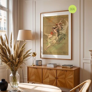 Op de afbeelding: Een ingelijste vintage poster met een bruine houten lijst. De poster toont drie figuren in vloeiende jurken, met de tekst "Kilimanjaro Design". De poster wordt getoond op een houten kast in een kamer met een raam en een vaas met gedroogde planten.