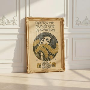 Peut inclure: Une impression encadrée rectangulaire avec le texte DEUTSCHE KUNST UND DEKORATION et VERLAG ALEX KOCH DARMSTADT. Le graphique central présente une illustration stylisée en noir et or d'un visage entouré de motifs floraux circulaires.