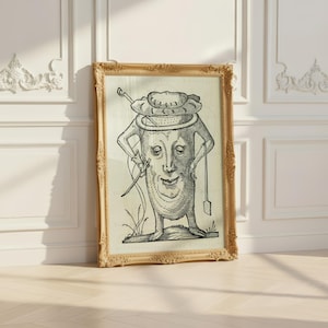 May include: A framed black and white line art print featuring a whimsical anthropomorphic character with a human-like face, wearing a wide-brimmed hat, holding a long thin staff in one hand and a small rectangular tool in the other, set in a gold frame.