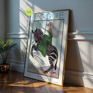 May include: A framed wall art print featuring a vintage Vogue magazine cover illustration. The artwork depicts a person in a green coat riding a zebra, with the text VOGUE at the top and Southern Fashions Number at the bottom, set in a gold frame.