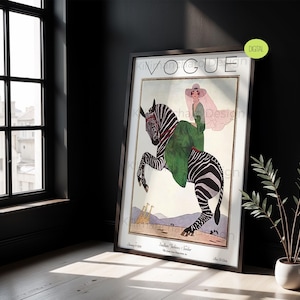 May include: A framed wall art print featuring a vintage Vogue magazine cover illustration. The artwork depicts a person in a green dress and wide-brimmed hat riding a zebra. The background shows a desert landscape with giraffes and the text VOGUE.