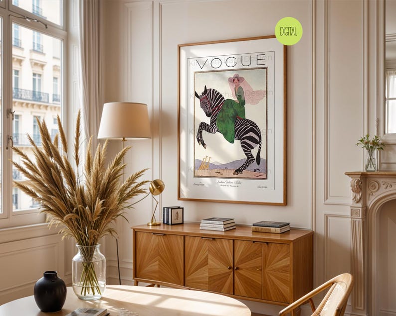 May include: A framed wall art print featuring a vintage Vogue magazine cover illustration. The artwork depicts a person in a green coat and pink hat riding a zebra, with two giraffes in the background. The text VOGUE is printed at the top.